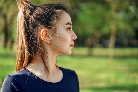 Portrait of a young smiling woman wearing sportswear in morning parkの写真素材