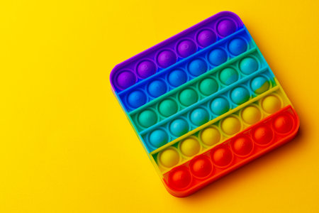 Colorful antistress pop it toy on yellow backgroundの写真素材