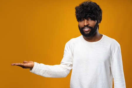 Young african american man cheerfully showing copy space