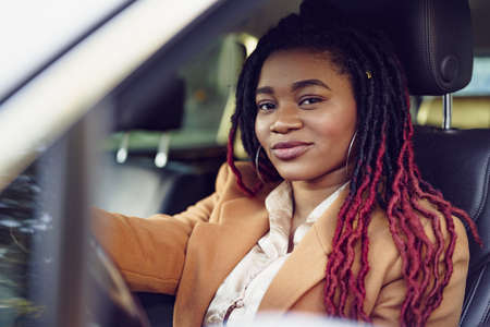 Portrait of positive african american lady inside the carの写真素材