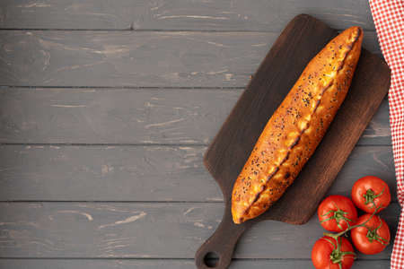 Turkish stuffed flatbread pide on gray wooden table