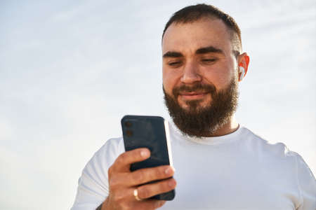 Young male using cell telephone while having a walk in countrysideの写真素材