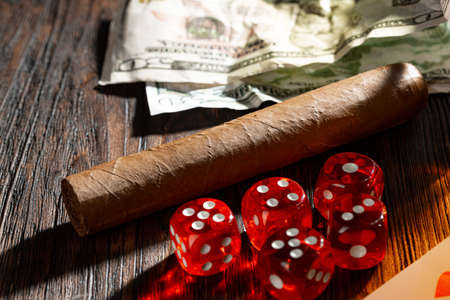 Close up of cigar and red dice cubes, gambling concept