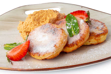 Cottage cheese pancakes with strawberry and sugar powder isolated