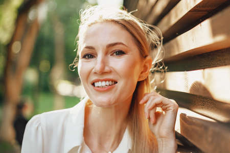 Attractive young stylish woman standing against wooden wallの写真素材