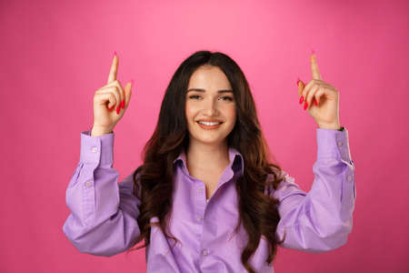 Yound beautiful brunette woman showing copy spaceの写真素材