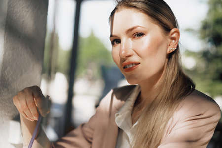 Beautiful young businesswoman drinking coffee in outdoor cafe
