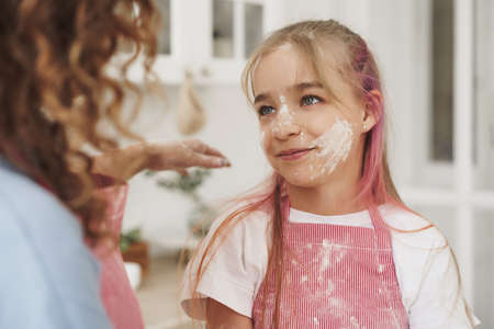 Mother and daughter having fun while cooking dough in kitchenの写真素材
