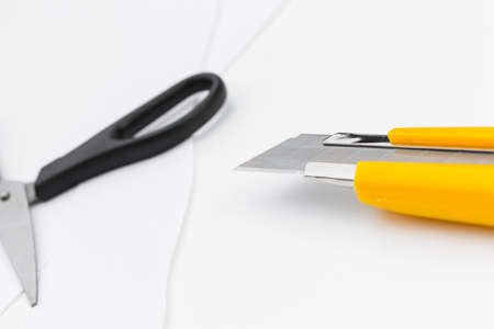 Scissors and paper knife on a white background