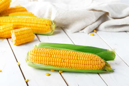 Raw corn on a wooden table