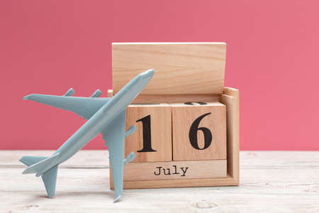 wooden cube shape calendar for july 16 on wooden tabletop