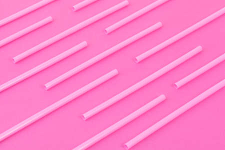Drinking straws on bright pink background, top viewの写真素材