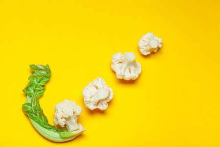 Cauliflower pieces on a bright yellow background