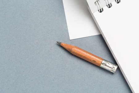Short worn pencil with notepad on gray deskの写真素材