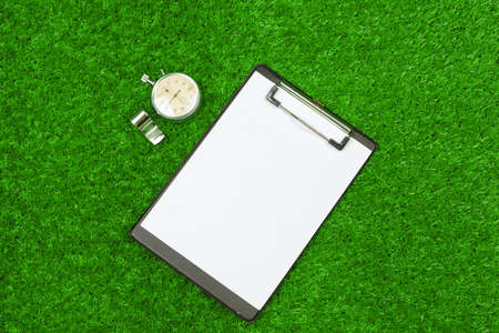 Sheet of paper and sports equipment on grass close-upの写真素材