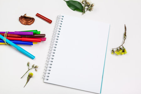 Set of felt tip markers in different colors and a blank sketchbook with a space for text