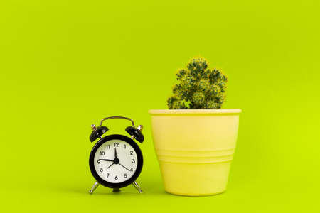 Vintage black alarm clock on a bright green background
