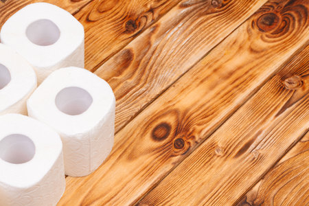 Toilet paper rolls on wooden background top viewの写真素材