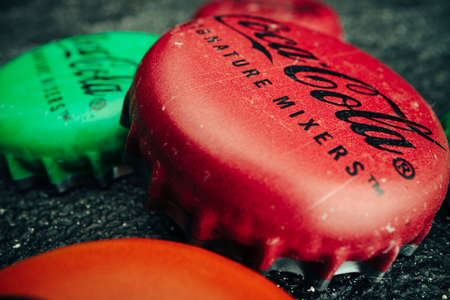KRASNODAR, RUSSIA - NOVEMBER 9, 2020: Macro photo of Coca Cola lids on grey textured backgroundのeditorial素材