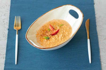 Bowl of oatmeal porridge with strawberry and mint