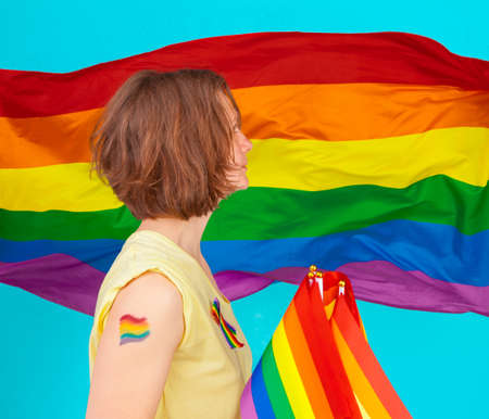 Rainbow flag. Woman holding and waving large LGBT flagの写真素材