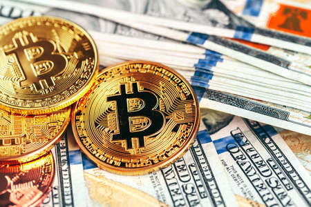 Golden bitcoin coins on a paper dollars money