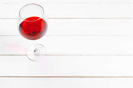 Goblet of red wine on wooden table on wooden wall backgroundの写真素材