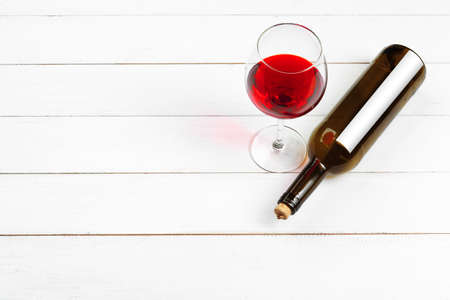 Goblet of red wine on wooden table on wooden wall background