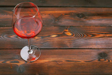 Goblet of red wine on wooden table on wooden wall backgroundの写真素材