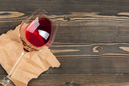 Goblet of red wine on wooden table on wooden wall backgroundの写真素材