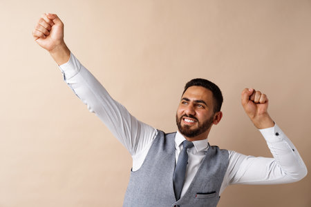 Young arab successful man celebrating triumph in studioの写真素材