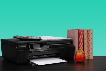 Home laser printer on desk against green backgroundの写真素材