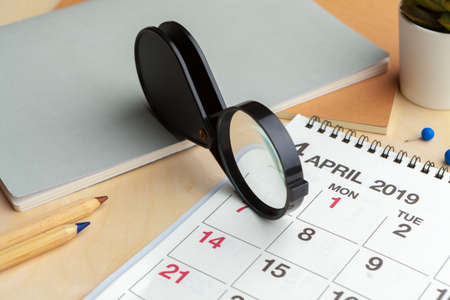 Concept image of business and meetings. Calendar to remind you an important appointment and Magnifying glassの写真素材
