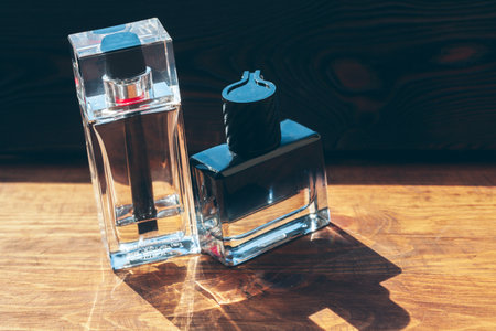 Black bottle of perfume placed on a wooden tableの写真素材