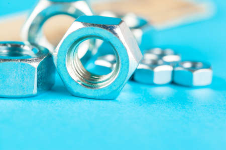 Blue industry or construction abstract background with various nuts on blue surfaceの写真素材
