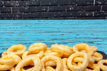 Pile of crispy onion rings on wooden backgroundの写真素材