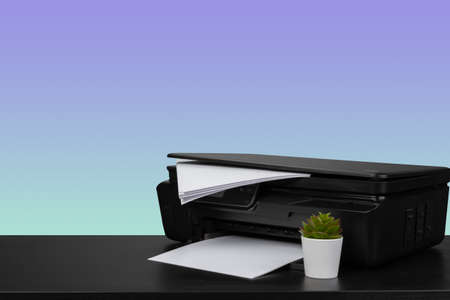 Home laser printer on desk against purple background