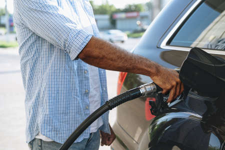 Man filling gasoline fuel in car at gas stationの写真素材