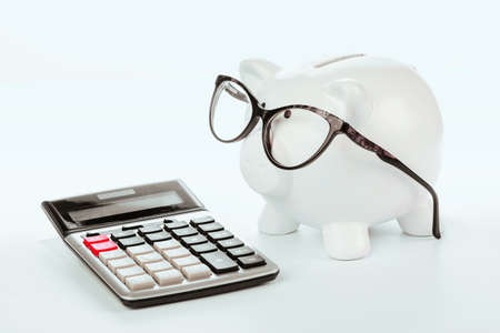 Piggy Bank with calculator on white backgroundの写真素材