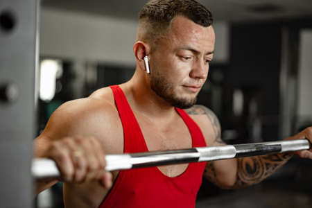 Strong man athlete exercise in gym, close up portrait