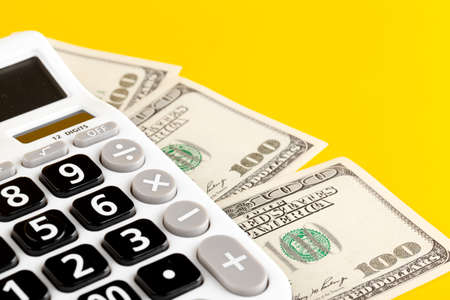 calculator and dollars on yellow background