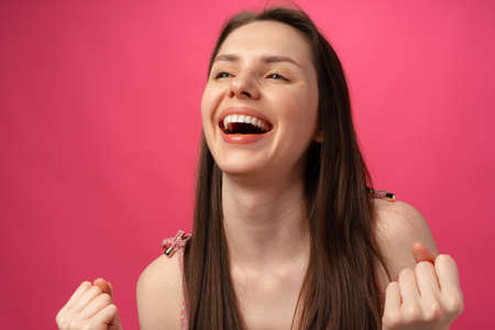 Portrait of a satisfied casual girl celebrating successの写真素材