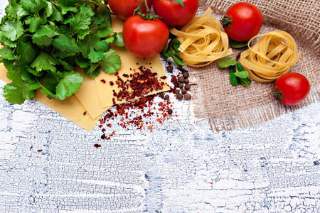 Pasta and ingredients on wooden background with copy space. Top view.の写真素材