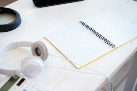 Open blank notepad and headphones on tableの写真素材