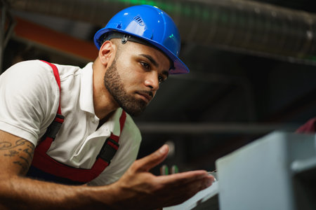 Portrait of african american male handyman working in an industrial factoryの写真素材