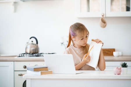 Young girl using laptop for homework at home