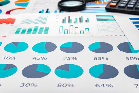Business graphs and magnifying glass on tableの写真素材