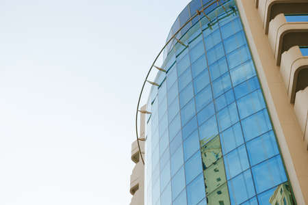 Glass skyscraper building with cloudy blue sky background