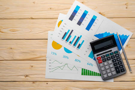 Business graphs paper and calculator on tableの写真素材