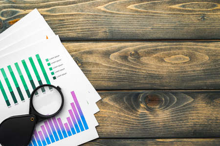 Business graphs and magnifying glass on tableの写真素材